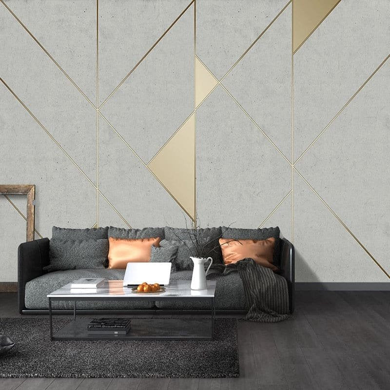 Art Deco geometric mural wallpaper in grey and gold shown in modern living room setting