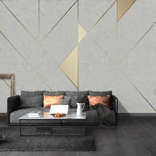 Art Deco geometric mural wallpaper in grey and gold shown in modern living room setting