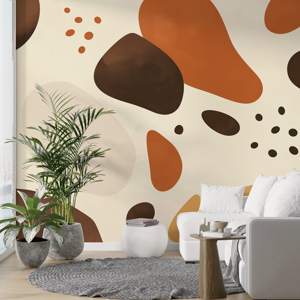 Abstract organic shapes mural wallpaper in terracotta and brown tones shown in a modern living room setting with plants