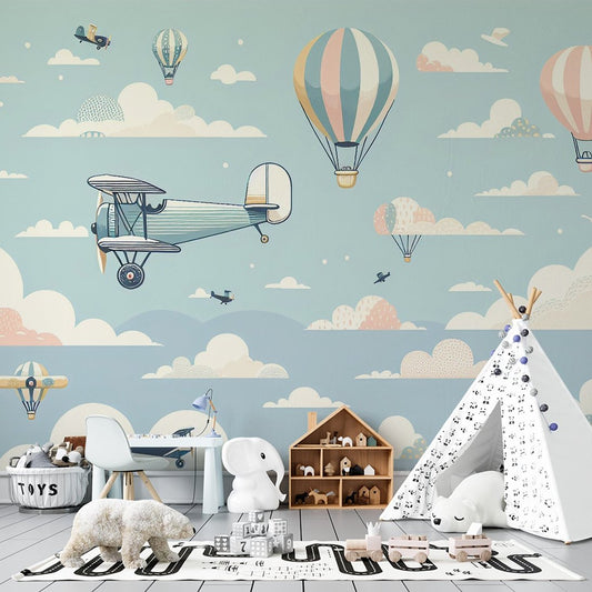 Vintage aviation mural wallpaper with hot air balloons and biplanes in pastel colors shown in nursery setting