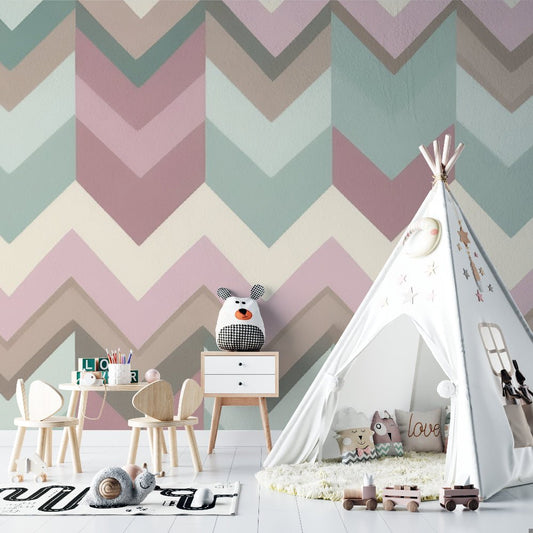 Geometric chevron mural wallpaper in pastel pink and sage green shown in modern nursery with teepee and wooden furniture