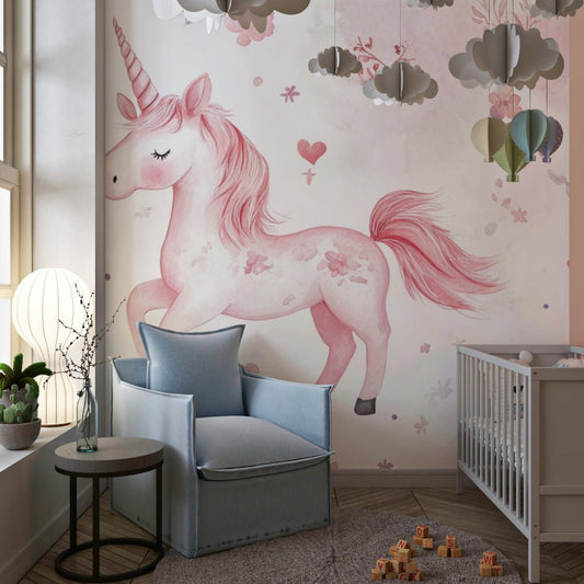 Pink unicorn mural wallpaper in nursery setting with gray armchair and cloud decorations