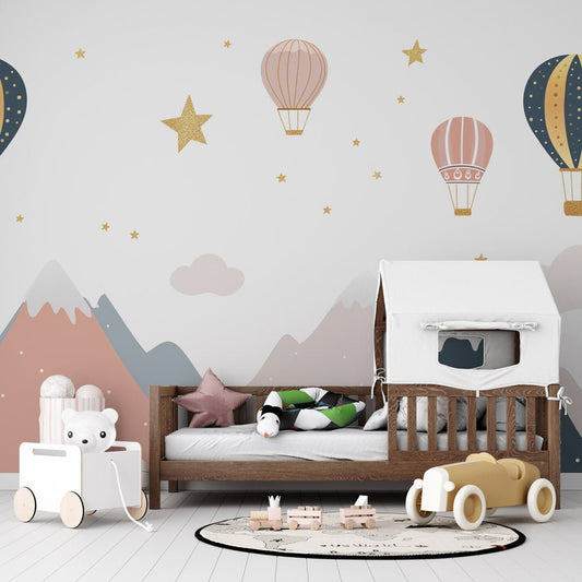 Mountain adventure mural wallpaper with hot air balloons and golden stars in a nursery setting