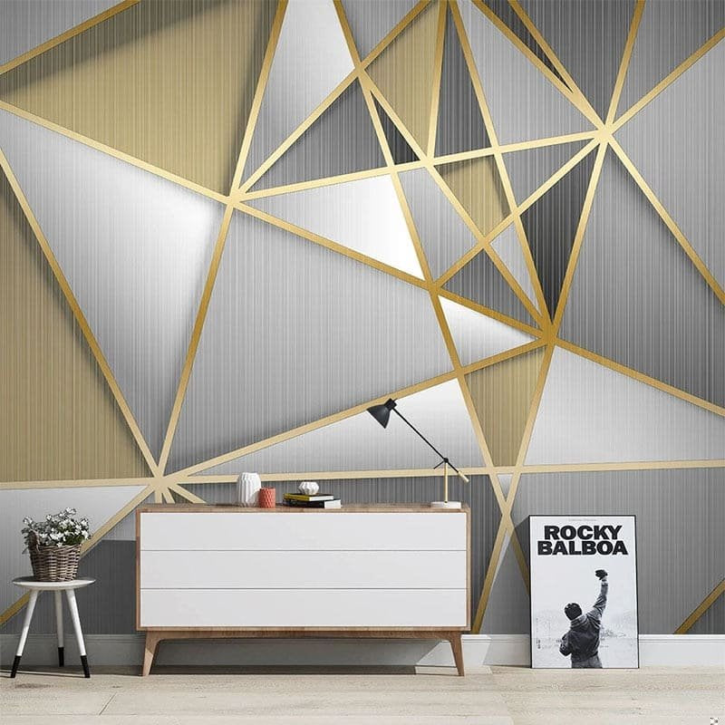 Art Deco geometric mural wallpaper with gold lines on grey background in modern living room setting