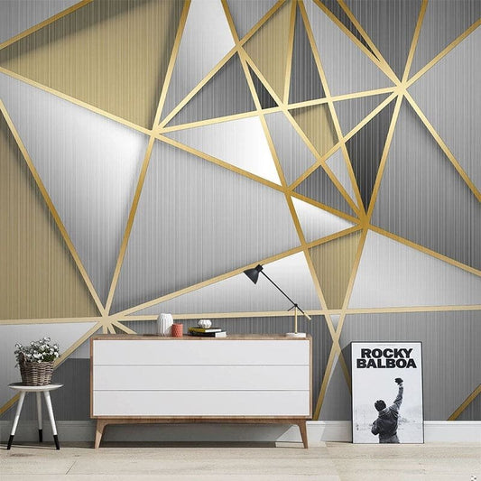 Art Deco geometric mural wallpaper with gold lines on grey background in modern living room setting