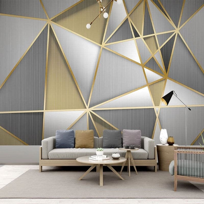 Modern Art Deco mural wallpaper featuring geometric patterns in grey and gold living room setup