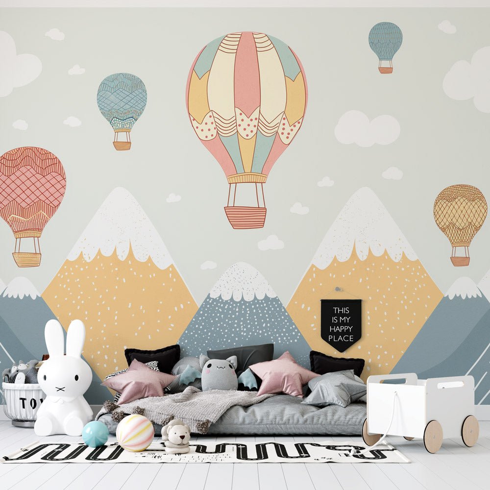 Hot air balloon mural wallpaper in pastel colors with mountain landscape, shown in a modern children's room setting