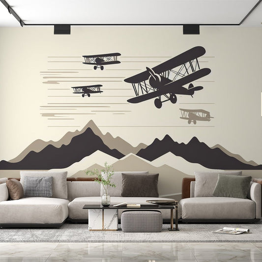 Vintage aviation mural wallpaper with black biplane silhouettes flying over minimalist mountain landscape in living room setting