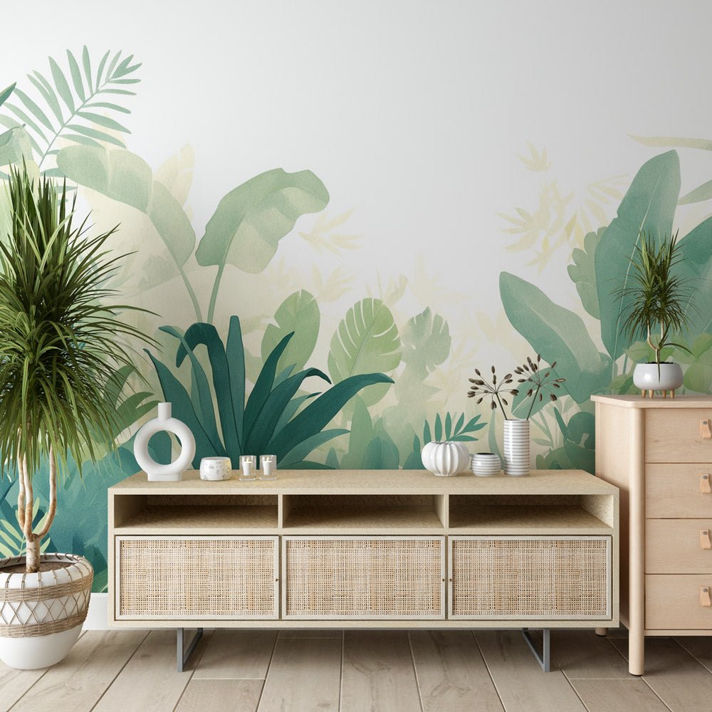 Tropical jungle mural wallpaper in sage green watercolor design shown in modern living room setting with rattan furniture